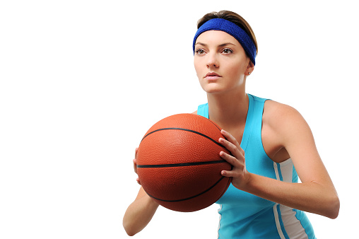 Close-up portrait of a young woman in sports outfit, holding a basketball and smiling during a training session. Focus on joy and athleticism.