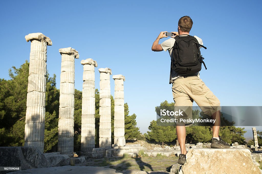 Rucksacktourist Tourist nimmt Foto von der griechischen Ruinen Säulen - Lizenzfrei Abgeschiedenheit Stock-Foto