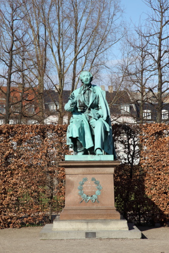 Sculpture of World Famous Danish fairy tale writer and poet Hans Christian Andersen (1805 - 1870) on his favourite spot in the Royal Garden (Kongens Have) Park of Copenhagen ready to read for the children.This (1823 - 1916) statue by August Saabye was errected in 1880.H.C.Andersen was quite a celebrity at his time.