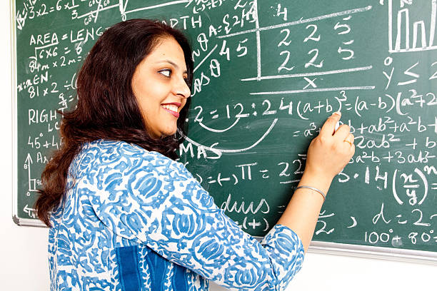 istock Young Cheerful Indian Mathematics Teacher in a Classroom 182709403