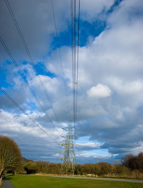 Powerlines leading to electricity pylon English countryside with power cable running towards a pylon. horizon over land stock pictures, royalty-free photos & images