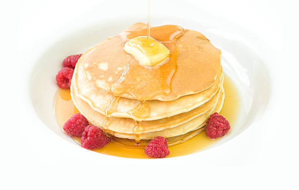 Pancake stack drizzled with maple syrup stock photo