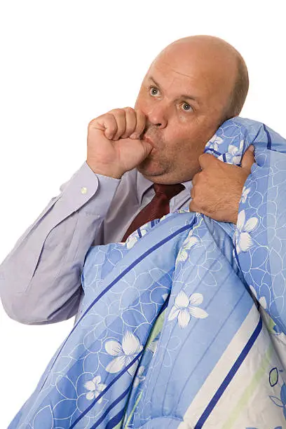 A business man sucking thumb and holding a security blanket - security concept.