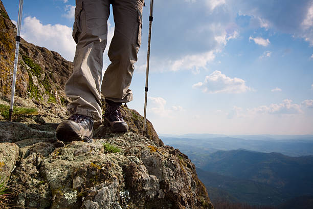 istock Person hiking on a high cliff with scenic background  182710398