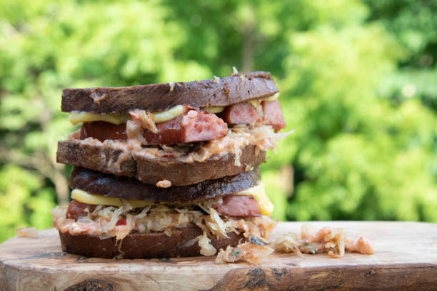 sanduíche de rúben com queijo gouda defumado escorrendo pelos lados. - sandwich reuben sandwich dining bread - fotografias e filmes do acervo