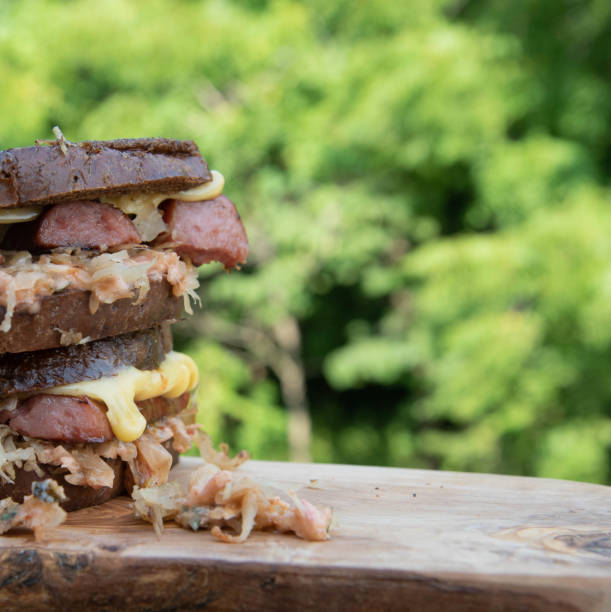 sanduíche de rúben com queijo gouda defumado escorrendo pelos lados. - sandwich reuben sandwich dining bread - fotografias e filmes do acervo