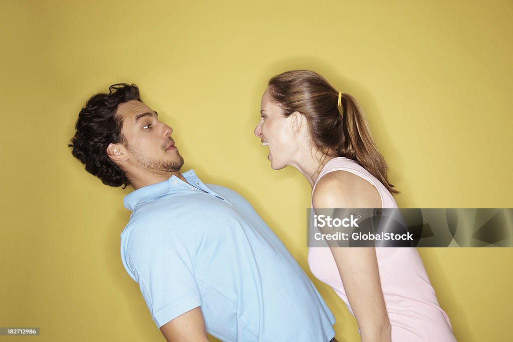 Mulher irritada Gritar em um homem contra fundo amarelo - Royalty-free Mulheres Foto de stock