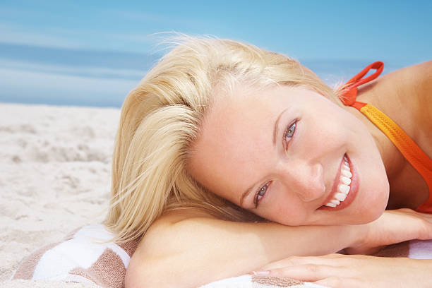 istock Attractive female lying on a beach against clear sky 182713895