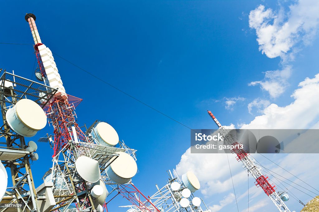 Communication towers stretching across the sky communication tower against blue cloudy skyCHECK OTHER SIMILAR IMAGES IN MY PORTFOLIO.... Below Stock Photo