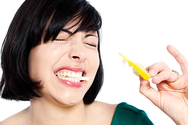 Young woman eating a lemon stock photo