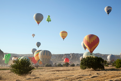 The early morning view of numerous hot-air balloons outside Goreme town in Cappadocia region (Turkey).