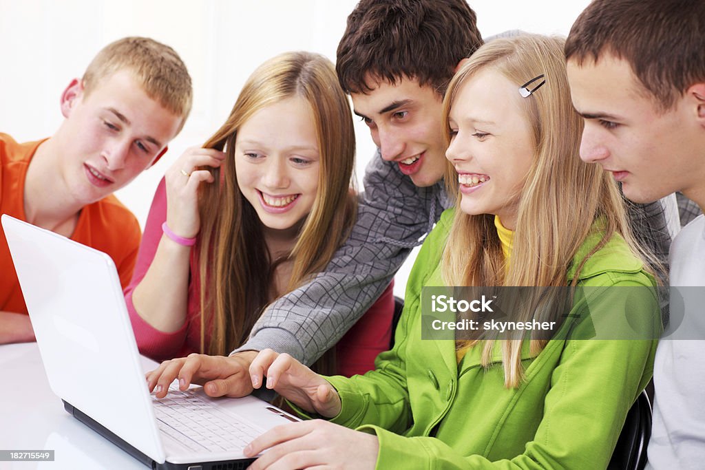 Smiling teens looking at laptop together. Smiling happy teens looking at laptop computer. Beautiful People Stock Photo