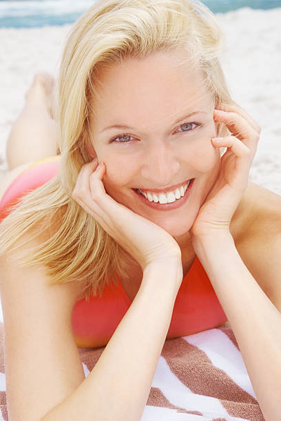 istock Attractive smiling female lying on beach 182715577
