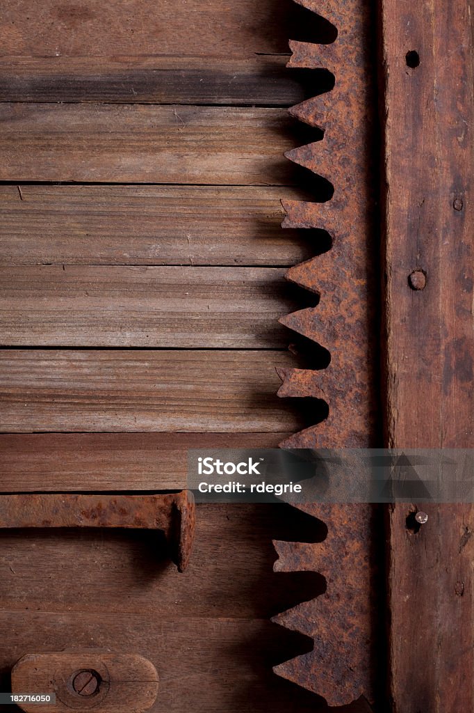 Rusty Old Tools and Wood Antique rusty old railroad spike, wrench, and saw blade sitting on old wooden planks with rusty nails. Antique Stock Photo