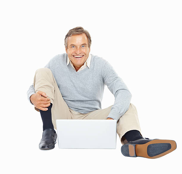 istock Smiling elderly man sitting and using a laptop on white 182716789