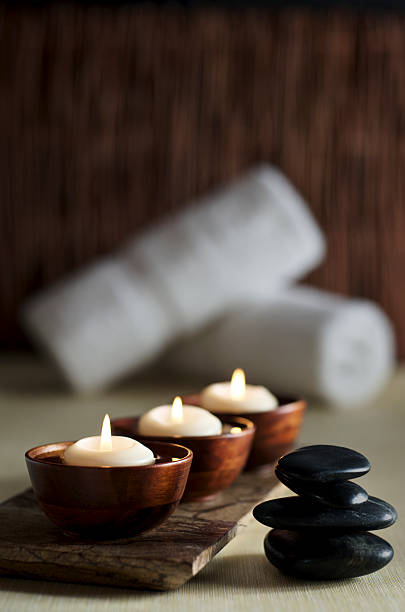 kerzen und massage steine in eine zen spa-hintergrund - wellness kerzen stock-fotos und bilder