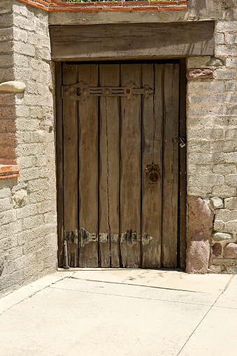 Ancient stone wall and wood gate with vintage hardware