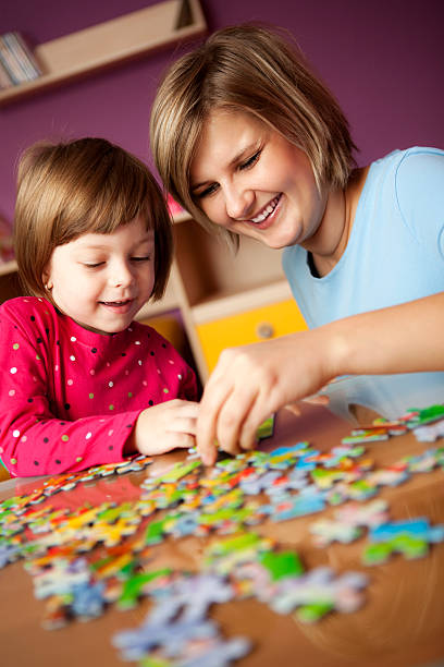 istock Mother helping her daughter with puzzle 182717633