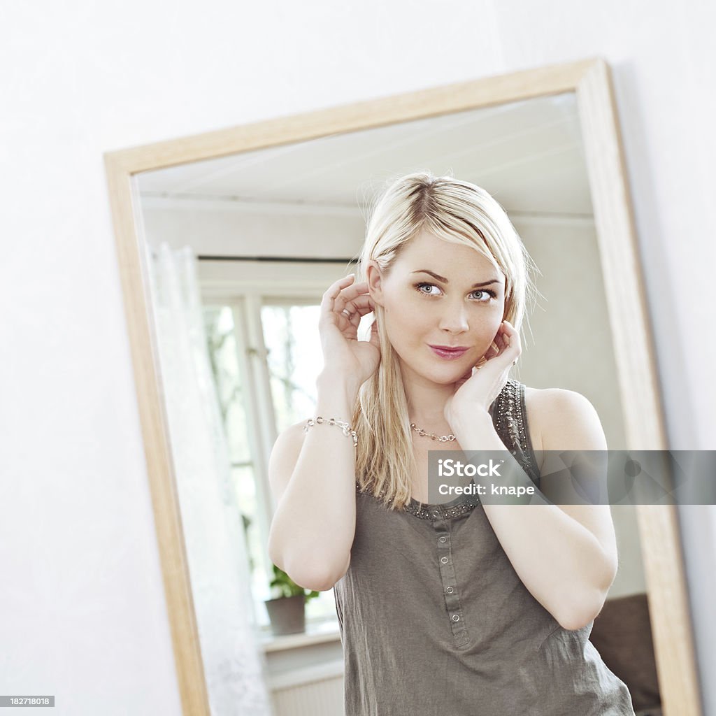 Mujer mirando a sí misma en un espejo - Foto de stock de 20 a 29 años libre de derechos