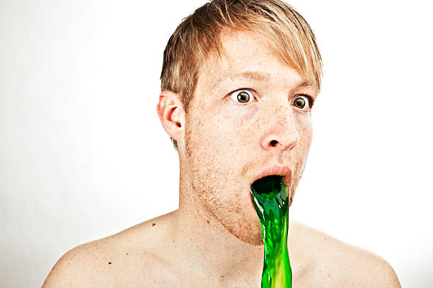 young man portrait indoor spitting something green young man portrait indoor... puke green color stock pictures, royalty-free photos & images