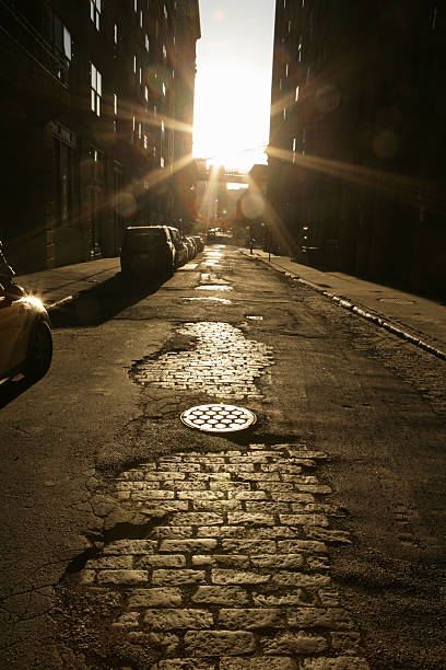 Damaged Brooklyn road with cobblestone underneath asphalt