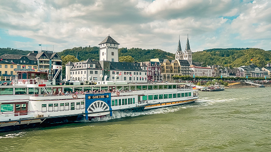 Kamp-Bornhofen, Germany, Europe, July 22, 2023 River cruise ship traveling in front of a beautiful medieval German village.