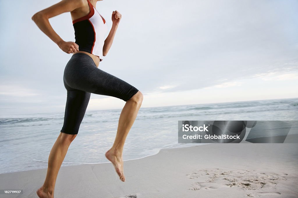image recadrée de femme jogging sur la plage - Photo de Adulte libre de droits