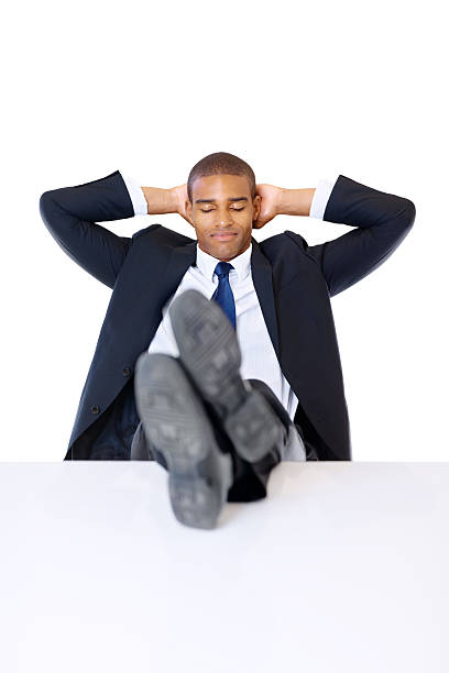 istock Business man with hands behind head and legs on table 182719940