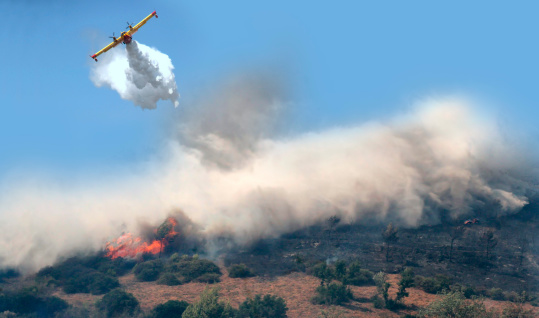Canadair while throwing water to put out a fire