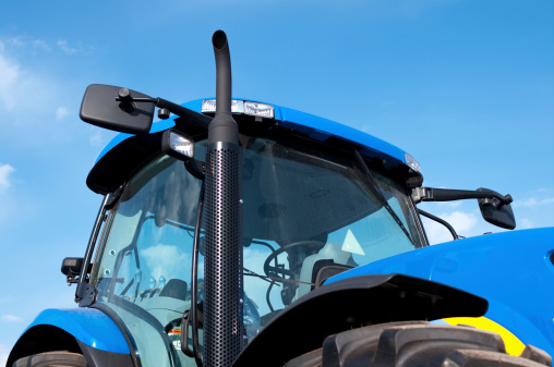 Close up view of a new blue farm tractor cab against a blue sky.Similar Images: