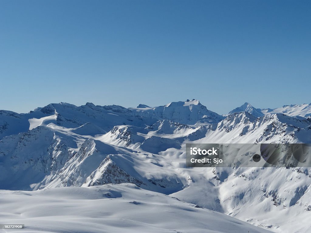 French Alps The mountains of the French Alps covered with snow under a blue sky with clouds. Scenics - Nature Stock Photo