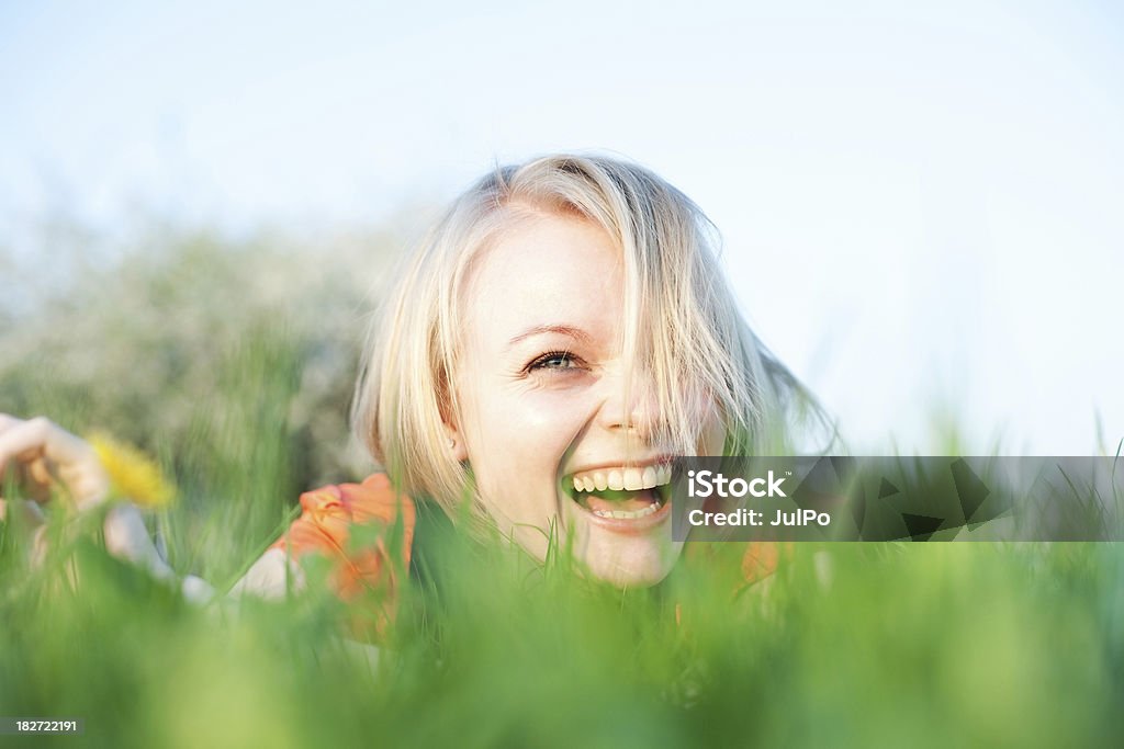 Happiness "Portrait of a young woman lying in grass, shallow DOF" Adolescence Stock Photo
