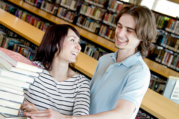 istock Young Couple with a Stack of Books at the Library 182722714