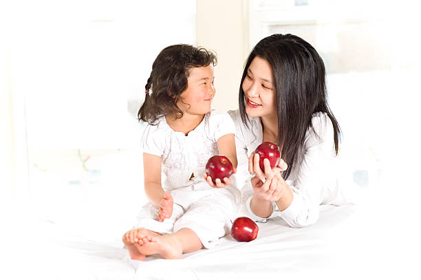 A pregant woman with a red apple in her hand