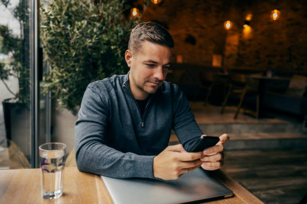 istock A young man is sitting in cafe and using his phone. 1827232566