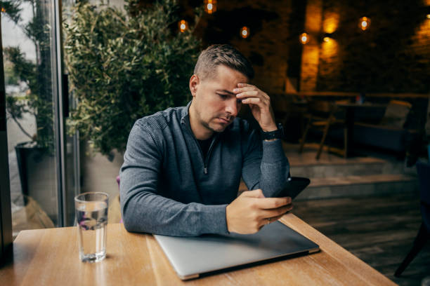 istock An anxious man is looking at his phone in coffee shop. 1827233421
