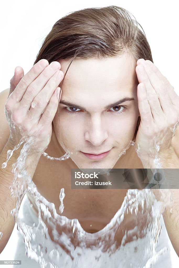 Adulto joven hombre refrescante con agua - Foto de stock de 20 a 29 años libre de derechos
