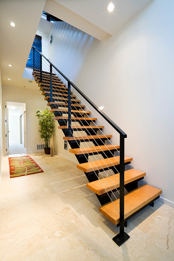 Light and shadow on surface of vintage stainless steel handrail with tile staircase outside of home in monochrome style and vertical frame