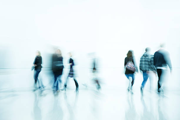 istock Pedestrians Walking Down Bright White Hallway, Blurred Motion 182723857