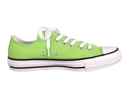 Side view of green athletic shoe with shoelace tied on white background