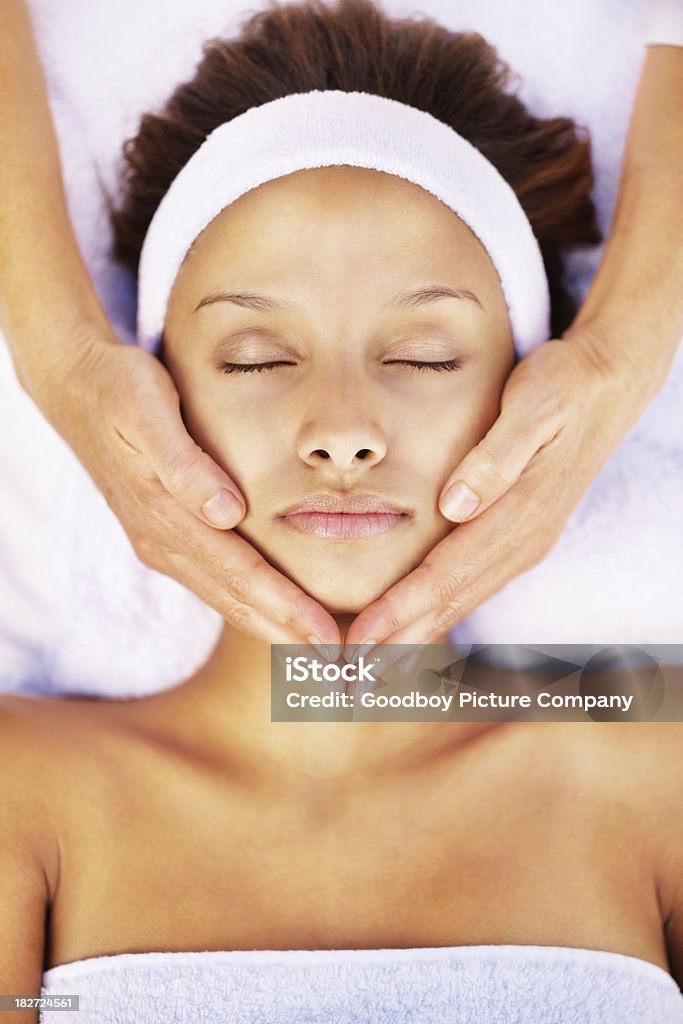 Tranquila mujer recibiendo un masaje facial - Foto de stock de 18-19 años libre de derechos