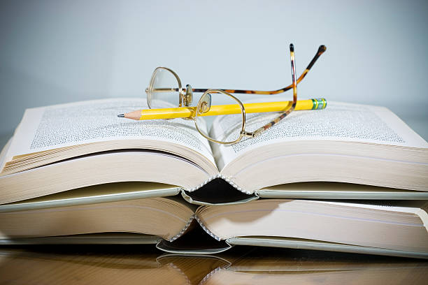 istock open books with pencil and eyeglasses 182725525