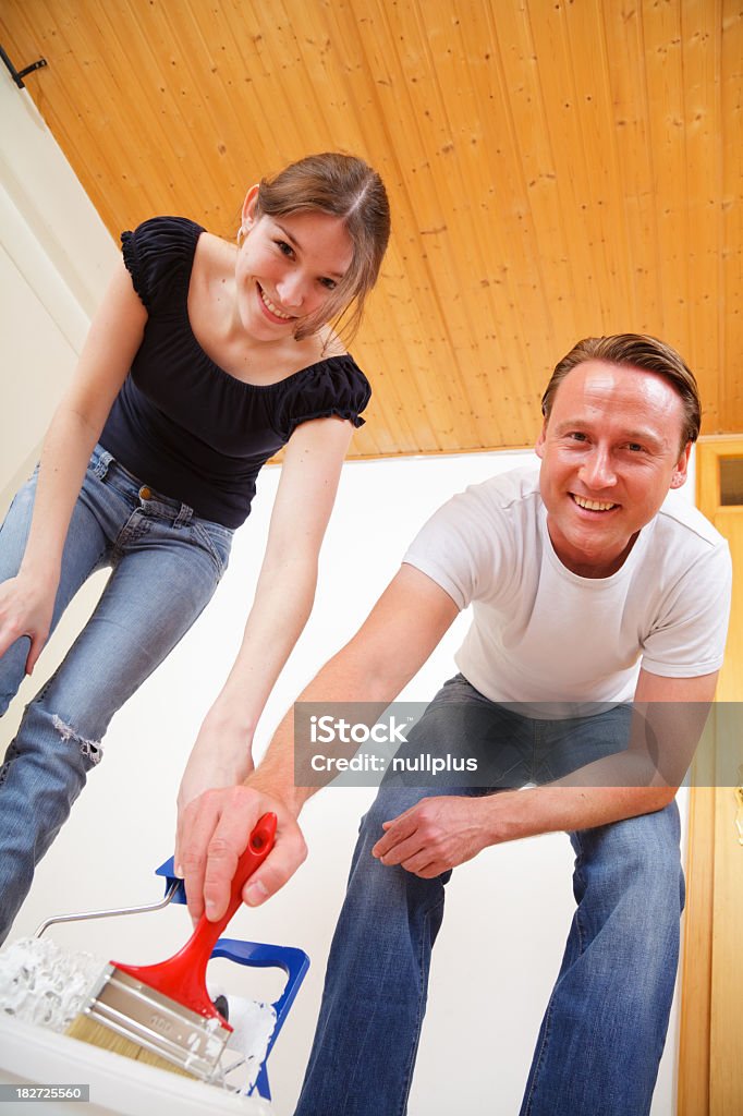 Jeune couple peinture sur les murs avec leur nouvel appartement - Photo de Adulte libre de droits