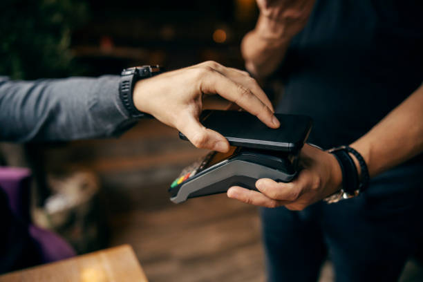 istock Close up of hand using app on smart phone for transaction on POS machine. 1827258041