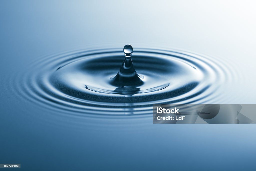 Drop falling in water Drop falling in blue water. Abstract Stock Photo