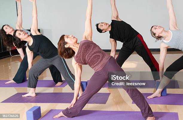 Foto de Classe Fazendo Ioga De Grupo Postura De Triângulo Estendida e mais fotos de stock de Adulto