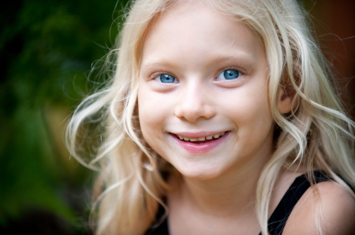 Close up face of a pretty little girl with big blue eyes. Click to see more...