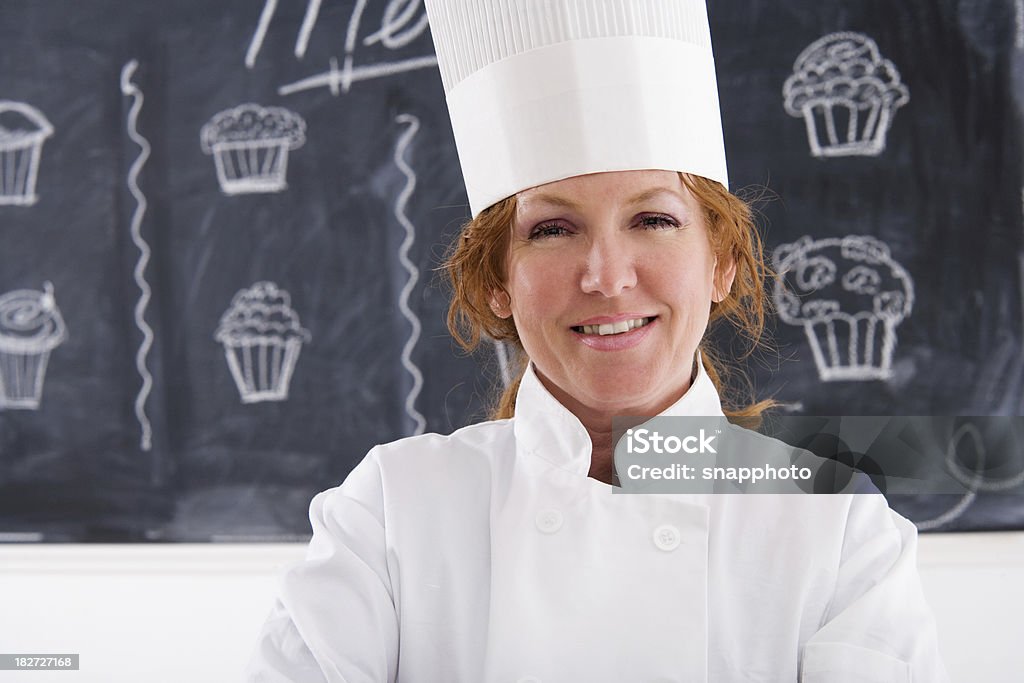 Chef hembra en la parte delantera del menú de planchar - Foto de stock de Adulto libre de derechos
