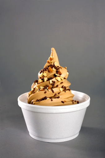 soft serve frozen yogurt in peanut butter/chocolate flavor topped with chocolate sprinkles and nuts