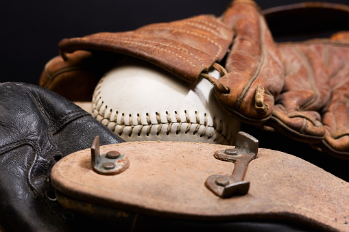 Vintage baseball cleats along with a glove and softball.